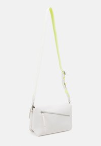Vit texturerad läderaxelväska med ett frontfack med blixtlås och ett avtagbart band i vitt och neon gult.