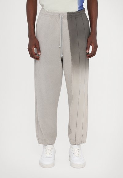 Šedé fleece kalhoty na jogging s gradientním designem, vybavené stahovací šňůrkou v pase, elastickými manžetami a kontrastními švy po stranách.
