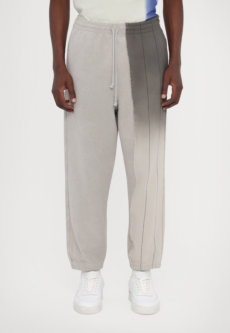 Gray fleece joggers with a gradient design, featuring a drawstring waist, elastic cuffs, and contrasting stitch lines down the sides.