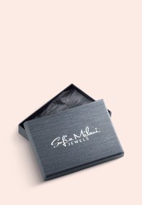 Grå smykkeboks med en struktureret overflade og et åbent låg, der afslører sort silkepapir indeni. Forsiden har "Sofia Milani JEWELS" i hvid tekst.