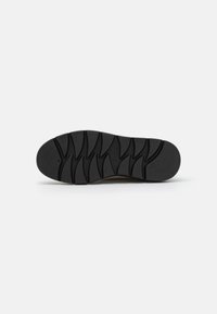 Schwarze Gummisohle mit strukturiertem Profilmuster, entwickelt für Grip und Langlebigkeit. Glatte Kanten, minimalistisches Design und keine sichtbaren Logos.