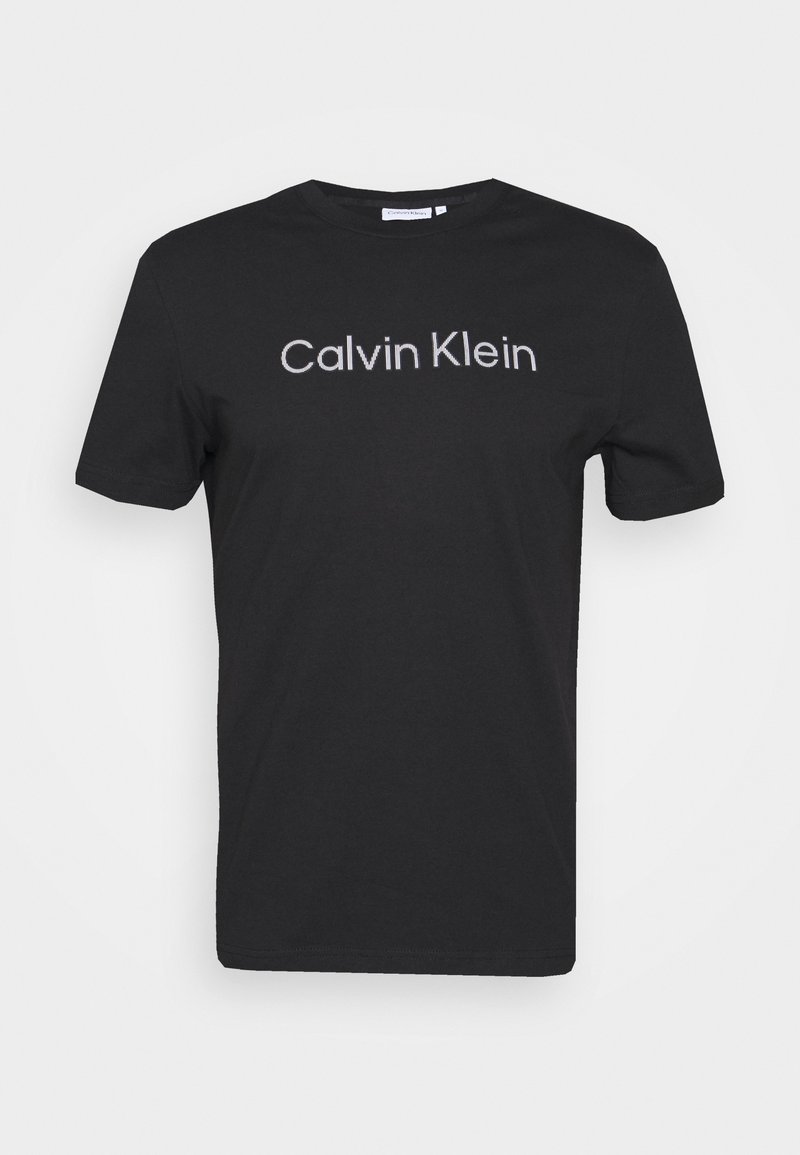 Černé tričko s krátkým rukávem a výstřihem ve tvaru kruhu s bílým logem "Calvin Klein" umístěným na středě přední strany.