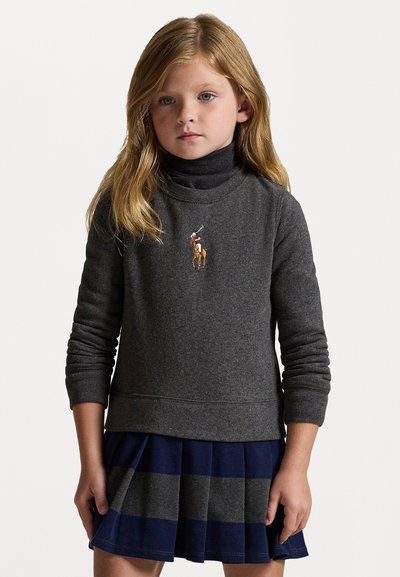 Sweatshirt cinza de pulôver com gola alta e design bordado equestre, combinado com uma saia plissada em azul marinho e cinza com riscas.