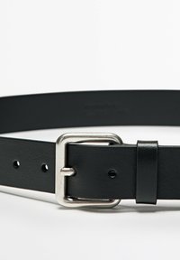 Cintura in pelle nera con fibbia rettangolare in metallo argentato, dotata di fori per la regolazione e una texture liscia e opaca.