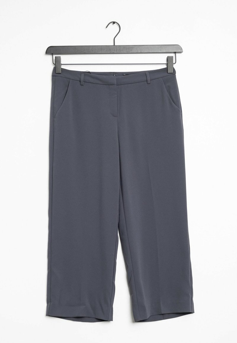 Grijze wijde broek gemaakt van gladde stof. Met schuine zijzakken en een lichte tapering bij de zoom. Hangt aan een zwarte hanger.