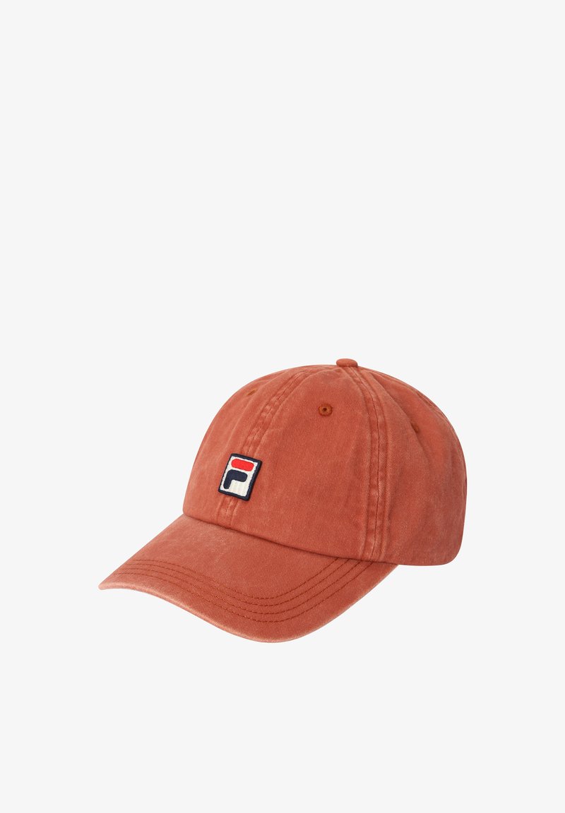 Honingkleurige baseballpet met gebogen klep en een klein vierkant logo met rode en marineblauwe vormen op een witte achtergrond aan de voorkant.