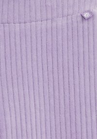 Tăsătură ribbed liliachie cu dungi verticale; textură moale; dispune de un etichetă mică cu un design de fulg de zăpadă în colțul din dreapta sus.