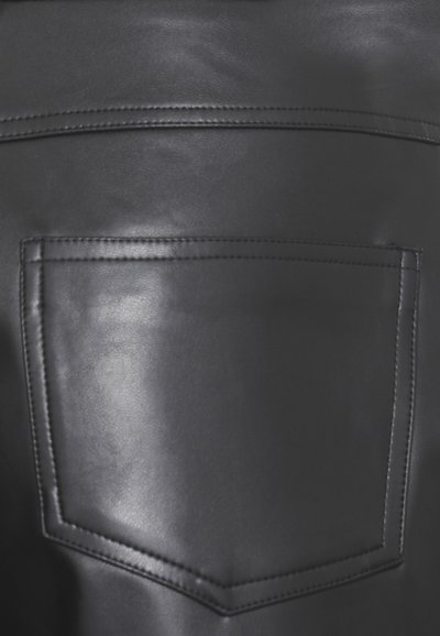 Tessuto in pelle nera caratterizzato da una tasca posteriore cucita di forma rettangolare e texture visibile. Finitura liscia con una leggera lucentezza.