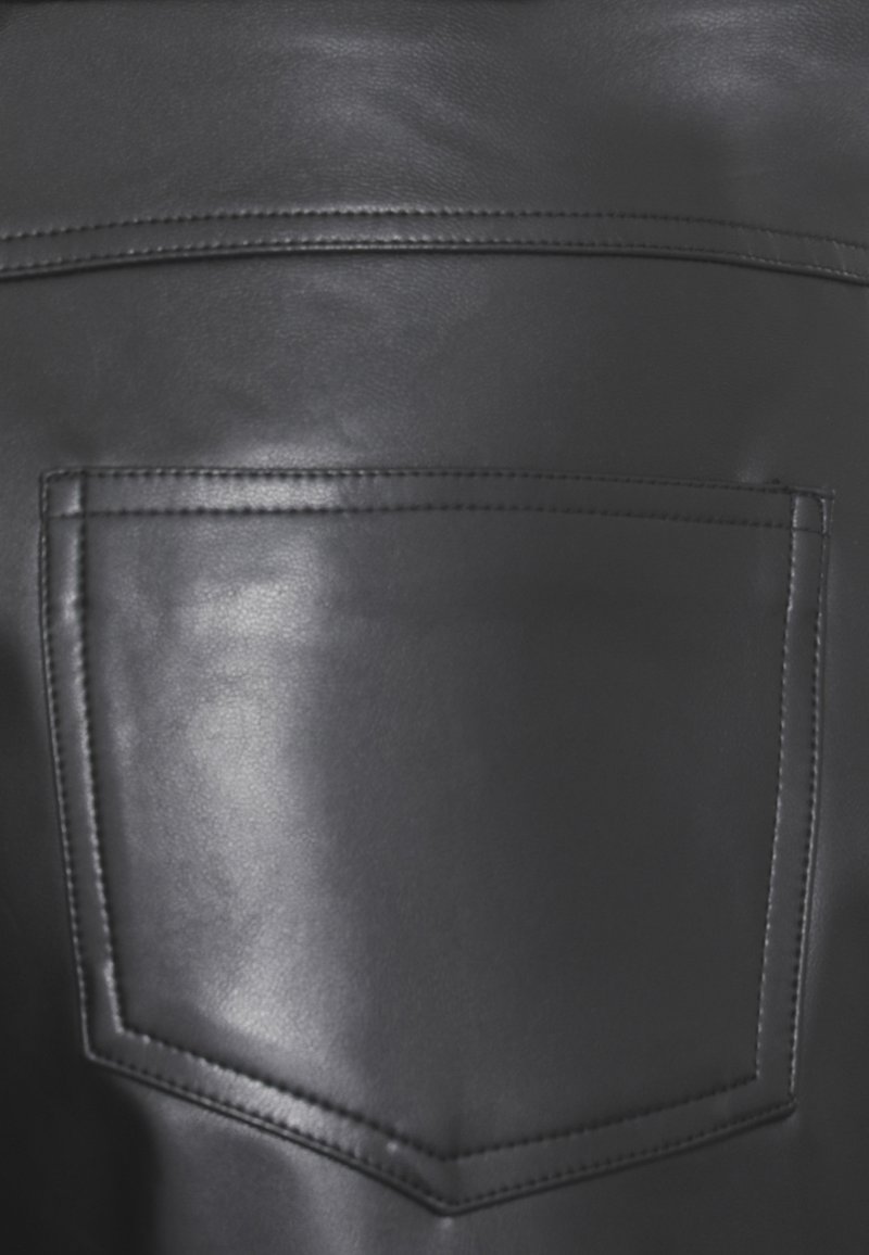 Tessuto in pelle nera caratterizzato da una tasca posteriore cucita di forma rettangolare e texture visibile. Finitura liscia con una leggera lucentezza.