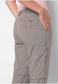 Helle graue Shorts mit glatter Textur, ausgestattet mit seitlichen Reißverschlusstaschen und einem regulären Bund. Sichtbarer Steppdetails am Saum.