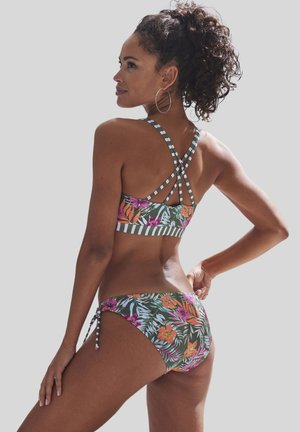 Ensemble de bikini floral avec un design feuillu en vert, orange et rose, avec des bretelles arrière rayées et un tissu texturé.