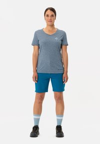 Modrá melírovaná v-neck tričko s logem, doplněné o šortky do kolen v královské modré barvě, světle modré a bílé pruhované ponožky a černé turistické boty.