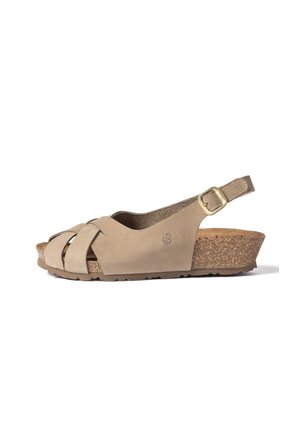 Sandale beige à bout ouvert avec des brides croisées, une boucle de cheville réglable, une semelle compensée en liège et une semelle extérieure en caoutchouc texturé pour une meilleure adhérence.