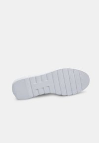 Witte sneakerzool met gestructureerde grip, voorzien van horizontale groeven en een platte vorm. Gladde materialen met subtiele merkaanduiding.