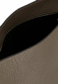 Borsa a tracolla in pelle taupe con finitura testurizzata e interno nero, caratterizzata da un bordo superiore liscio e da un sottile dettaglio con zip lungo l'apertura.