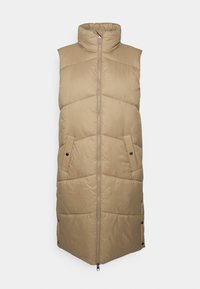 Gilet matelassé sans manches beige avec col haut, motif matelassé en diagonale, fermeture éclair à l'avant et deux poches latérales avec fermetures à pression.