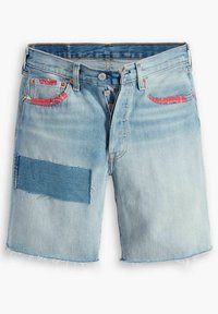 Ljust blå denimshorts med fransad nederkant, med fickor accentuerade i röd och en texturerad blå lapptäck på vänster ben.