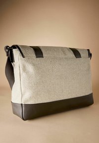 Gray felt messenger bag with dark leather accents, rectangular shape, top flap closure, and adjustable shoulder strap. Smooth texture.