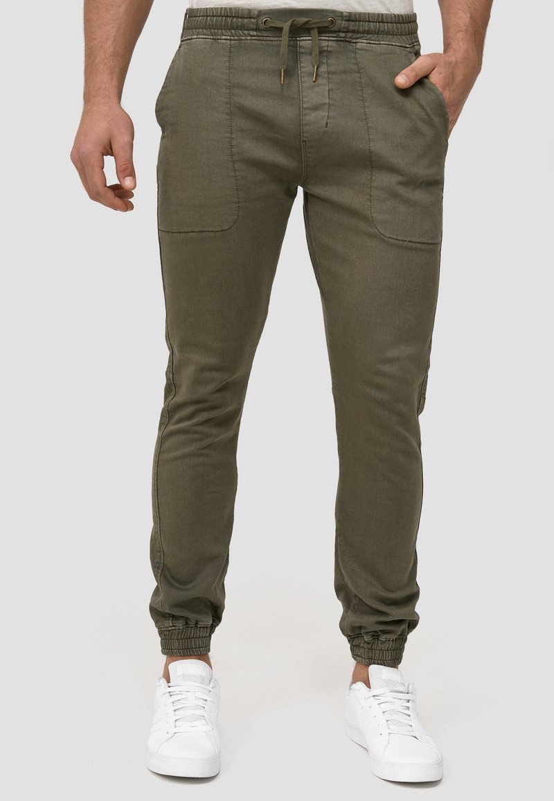 Pantalones jogger de color verde oliva, confeccionados en un tejido ligero, con cintura elástica, cordón de ajuste, bolsillos laterales y puños ajustados.