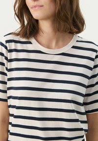 Striped t-shirt made of soft cotton, featuring horizontal navy stripes on a cream background, round neckline, and short sleeves.