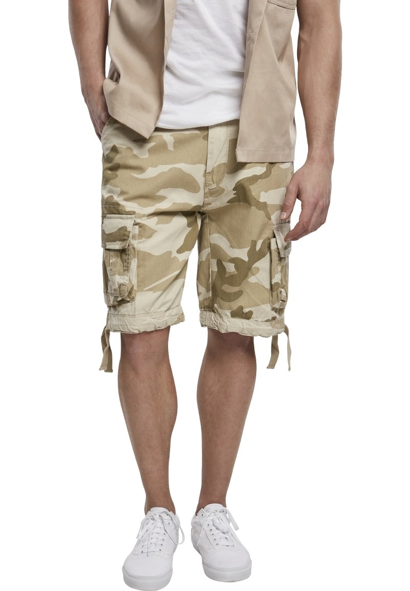 Beige camouflagemönstrade cargoshorts med flera fickor, dragsko i nederkant och en avslappnad passform, tillverkade av andningsbart material. Bärs med vita sneakers.