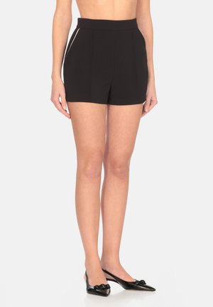 Pantaloni corti neri a vita alta con una texture liscia, dotati di tasche laterali e piping a contrasto lungo le cuciture.