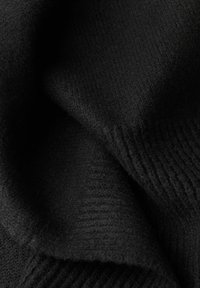 Tessuto di maglia nera con una superficie morbida e texturizzata, caratterizzato da sottili motivi a coste. Il materiale appare caldo e leggermente lanoso.