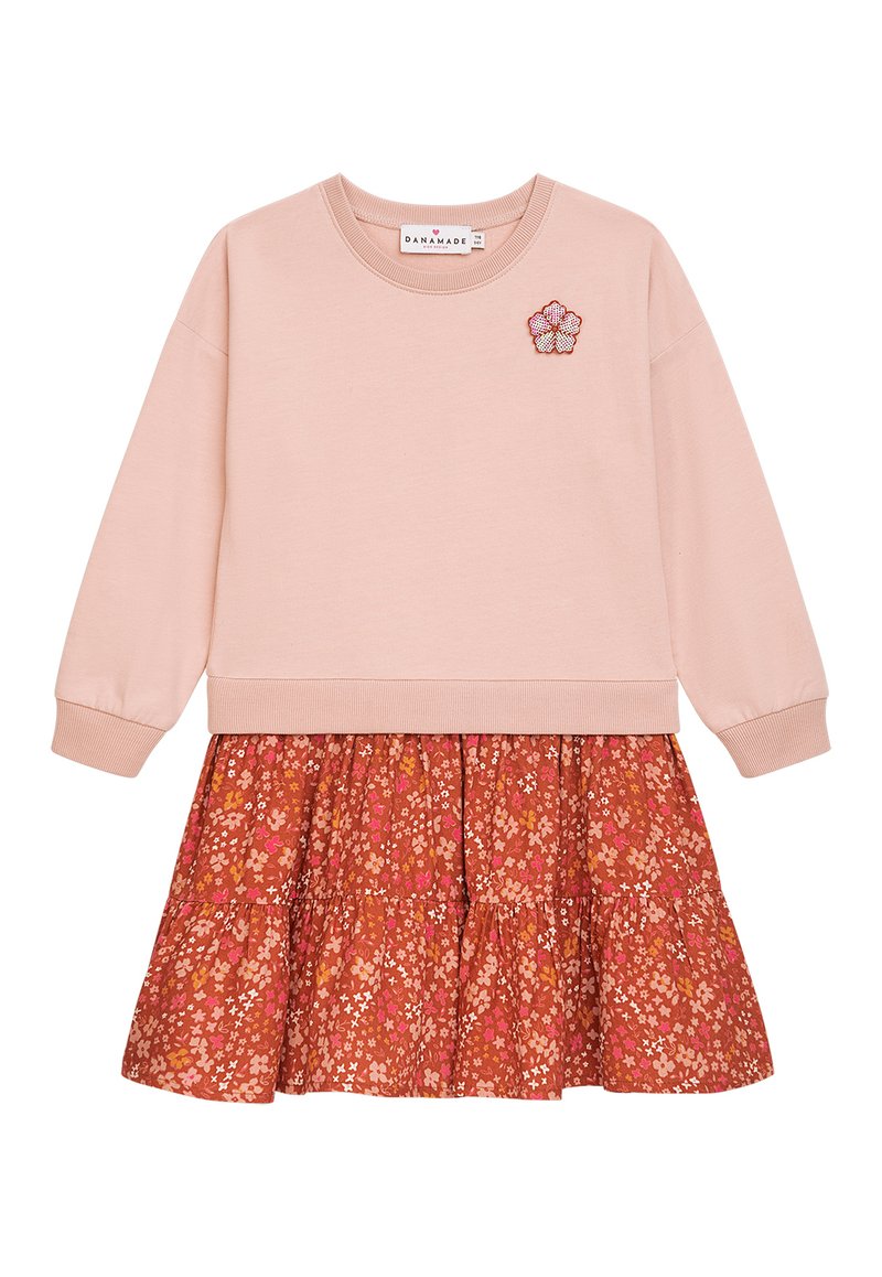 Hellrosa Sweatshirt mit Rippbündchen, kombiniert mit einem gestuften Rock im rostfarbenen Muster, der kleine Blumenmuster aufweist. Besticktes Blumenakzent.