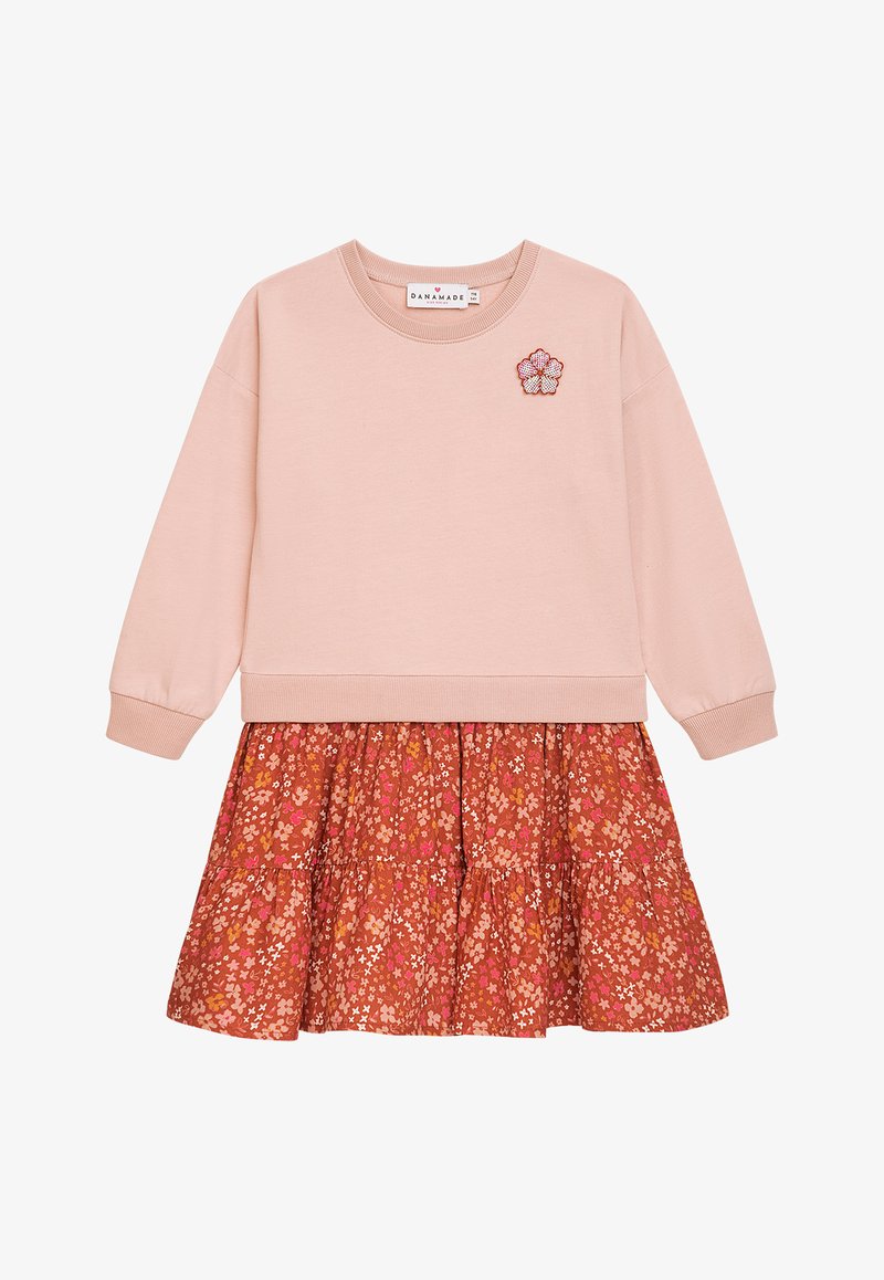 Hellrosa Sweatshirt mit Rippbündchen, kombiniert mit einem gestuften Rock im rostfarbenen Muster, der kleine Blumenmuster aufweist. Besticktes Blumenakzent.