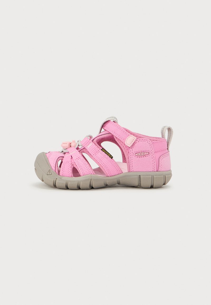 Pink children’s sandals with a fabric upper, open-toe design, grey rubber sole, adjustable straps, and a loop at the back for easy wear.
