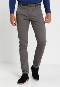 Gråmönstrade chinos med slim fit, tillverkade av bomullsblandat tyg, kombinerade med svarta mockaskor och ett brunt läderbälte.