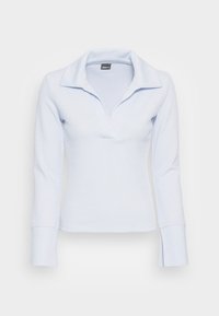 Haut à manches longues bleu clair avec une texture côtelée, doté d'un col à encolure notée et de poignets évasés. Le tissu semble doux et flexible.