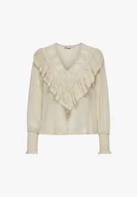 Blusa color crema con escote en V y ribete de encaje con volantes. Presenta puntos texturizados, mangas largas con puños fruncidos y cierre de botones.