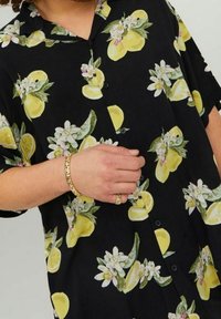 Zwarte kortekrongs T-shirt met gele citroen- en bloemenprint, met een knoopsluiting aan de voorkant en een ontspannen, losse pasvorm.