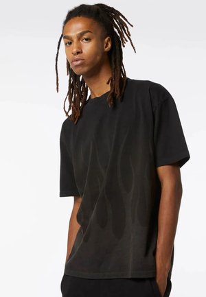 T-shirt nero a maniche corte con motivo a fiamma, realizzato in tessuto morbido. Presenta un girocollo e una vestibilità ampia.