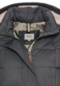 Donkerblauwe geïsoleerde jas met een doorgestikte textuur. Ritsluiting, lichtgrijze binnenvoering en een label met "Camel Active." Voorzien van een capuchon.