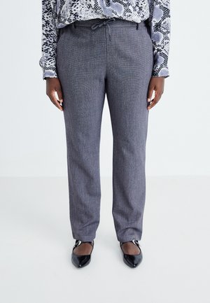 Pantalon texturé gris avec taille à cordon, coupe droite, associé à un chemisier à manches longues à motifs et des chaussures noires à talons pointus.