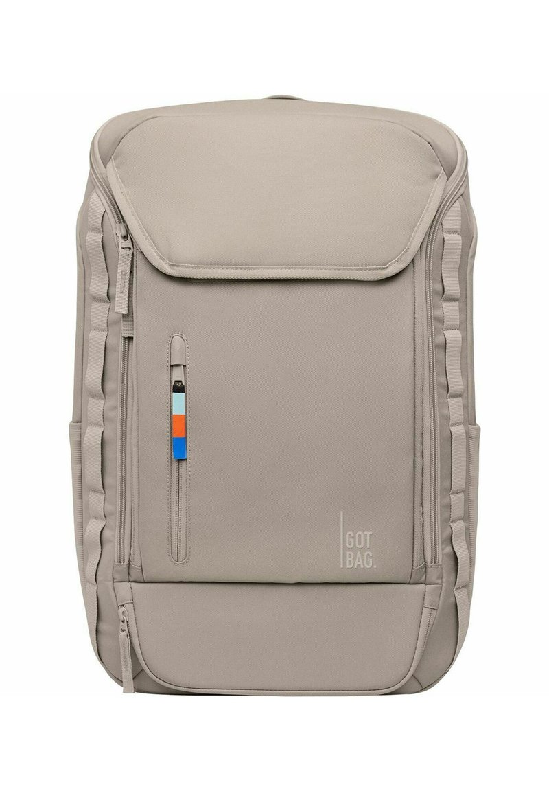 Sac à dos en tissu beige avec une fermeture à rabat, une poche zippée sur le côté et un accent coloré. Il dispose de côtés rembourrés et d'un logo de marque discret.