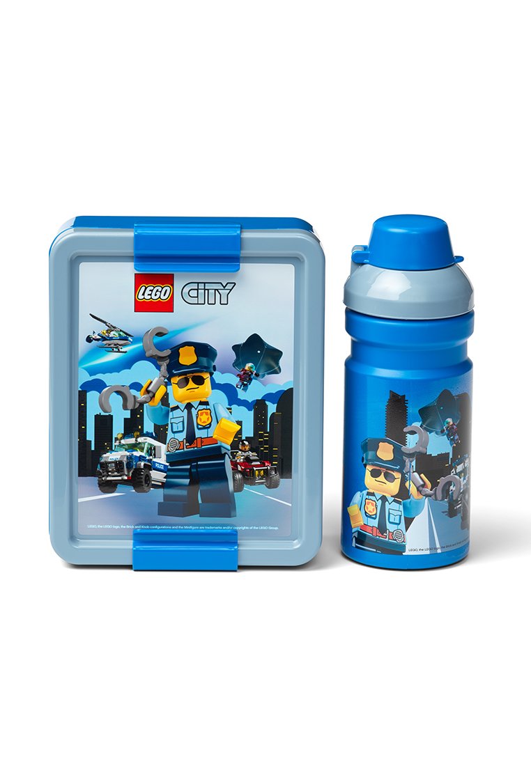Pudełko na lunch i butelka wody z minifigurką policjanta z LEGO City trzymającą kajdanki, z radiowozami i tłem przedstawiającym panoramę miasta.