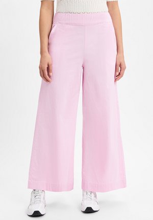 Helle rosa, weit geschnittene Hose aus glattem Stoff mit Seitentaschen, bietet einen entspannten Schnitt und einen sauberen Saum. Kombiniert mit weißen Sneakern.