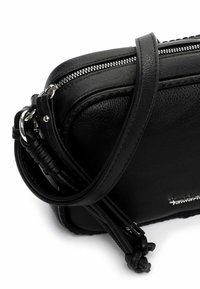 Musta nahkainen olkalaukku, jossa hopeanvärinen vetoketju, teksturoitu pinta, punottuja hihna-aksentteja ja pieni logoyksityiskohta.