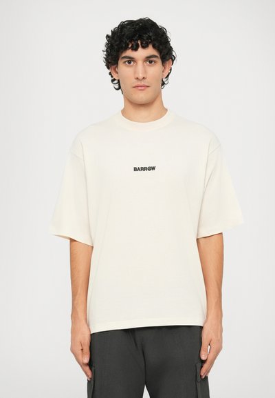 T-shirt oversize color crema, realizzata in cotone morbido, con un logo nero "BARROW" stampato sul petto. Design a maniche corte e collo girocollo.