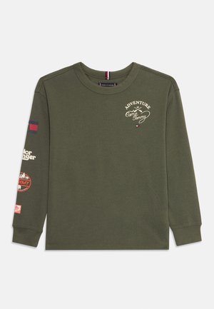 Olivgrünes Langarmshirt mit dem Schriftzug "Adventure at Camp Tommy" und Logos auf Brust und linkem Ärmel, Rundhalsausschnitt und gerippten Bündchen.
