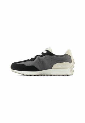 Sneaker New Balance grigio e nero con suola bianca, lacci bianchi e dettaglio sul tallone beige su sfondo bianco.