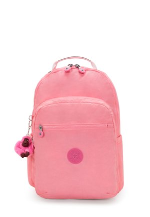 Pink nylon backpack with two zippered compartments, a round logo patch, and a fluffy monkey keychain accent. Smooth texture and rounded shape.
