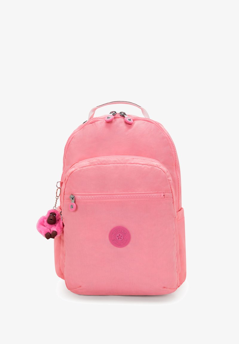 Růžový nylonový batoh se dvěma zipovými kapsami, kulatou logovou nášivkou a měkkým monoklíčkem ve tvaru opičky. Hladký povrch a zaoblený tvar.