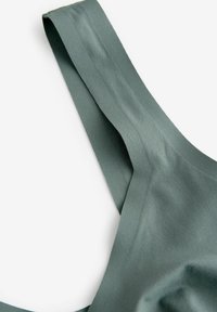 Roheline satiinkangas, millel on sile tekstuur, ja laiem, lame rihm, mis kumeralt käändub. Disain on minimalistlik ja tagasihoidlik.