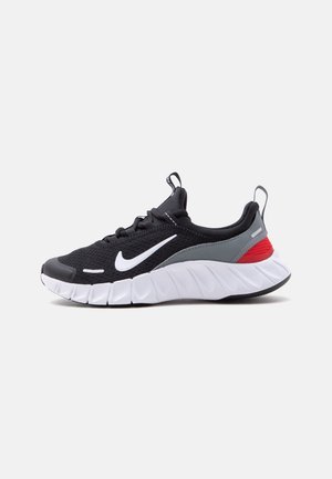 Musta Nike-juoksukenkä valkoisella swoosh-logolla, harmailla ja punaisilla yksityiskohdilla sekä paksulla valkoisella pohjalla, esitetty sivulta valkoisella taustalla.