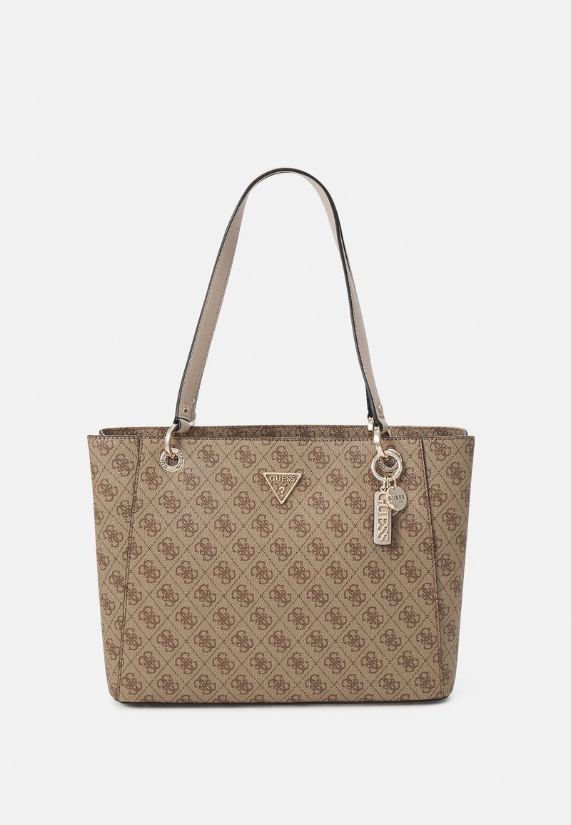 Sac cabas beige Guess avec motif logo sur toute la surface, deux bretelles et des étiquettes logo Guess en métal accrochées près de la poignée.