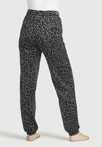 Grau und schwarze Sweatpants im Leopardenmuster, mit einem elastischen Bund und schmaler werdenden Knöcheln, aus einem weichen, strukturierten Stoff gefertigt.